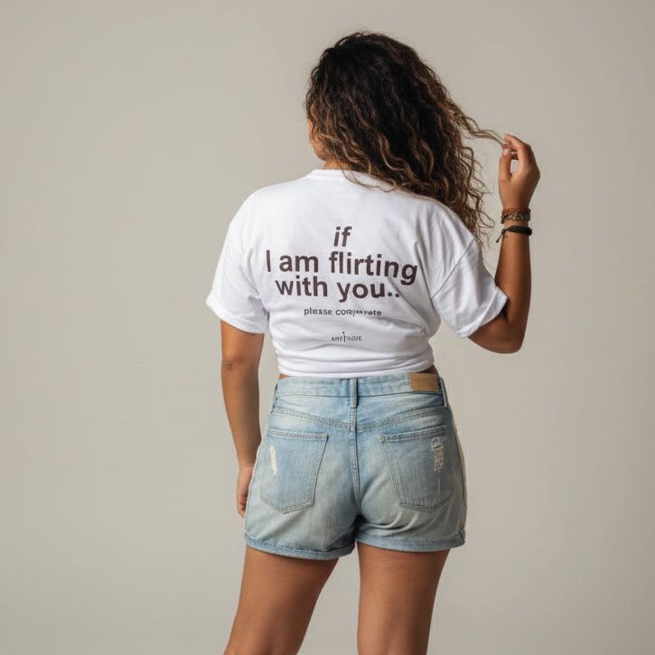 White t-shirt with black text reading ‘If I am flirting with you please coordinate’ displayed on a plain background