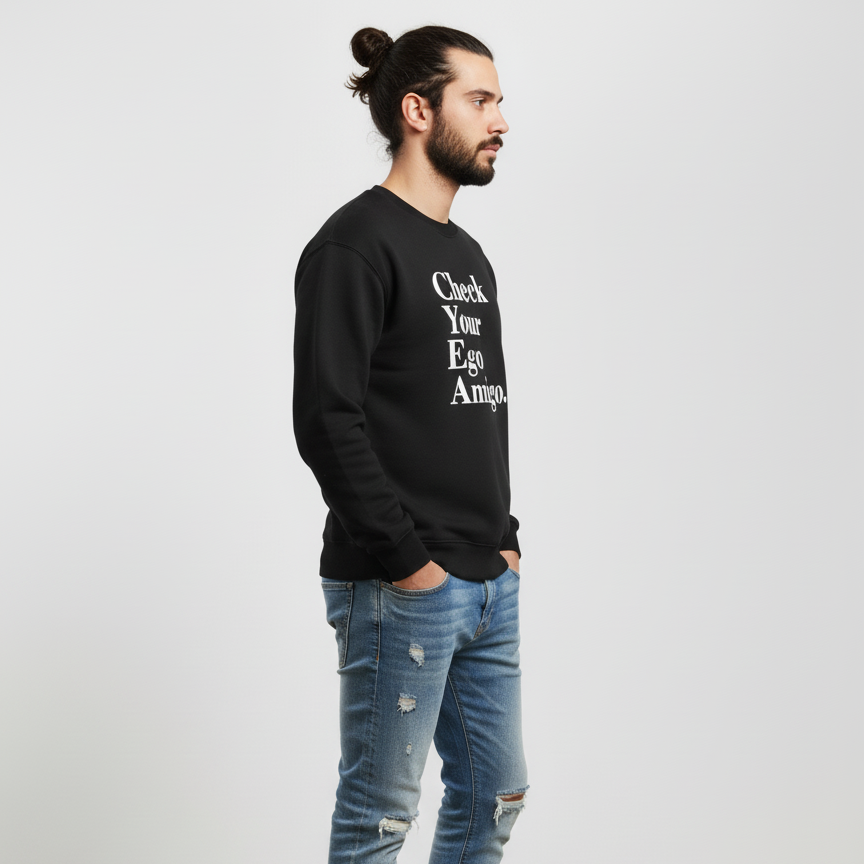 Man wearing a black sweatshirt with text and blue jeans on a light gray background
