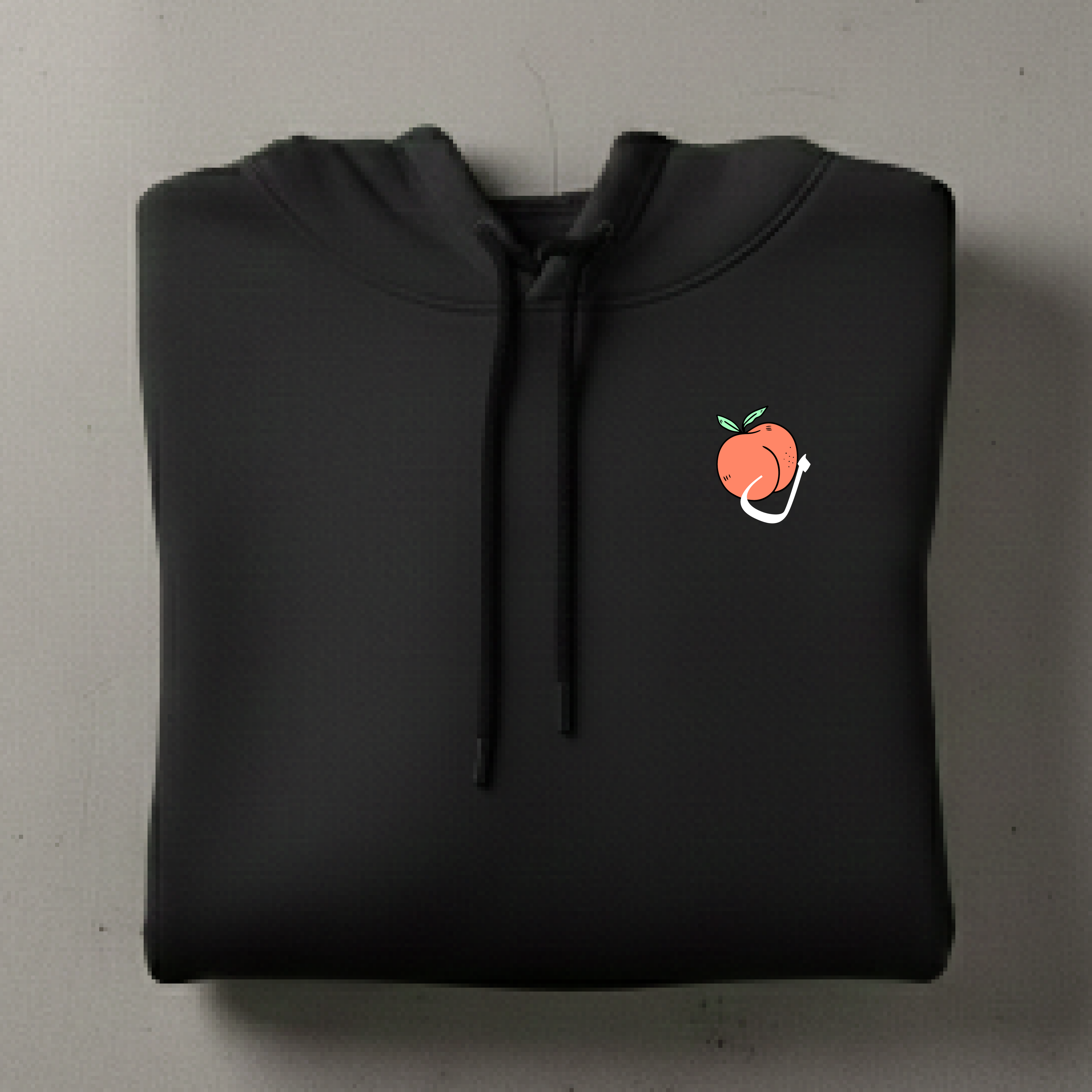 Black hoodie with a small peach design on a gray background