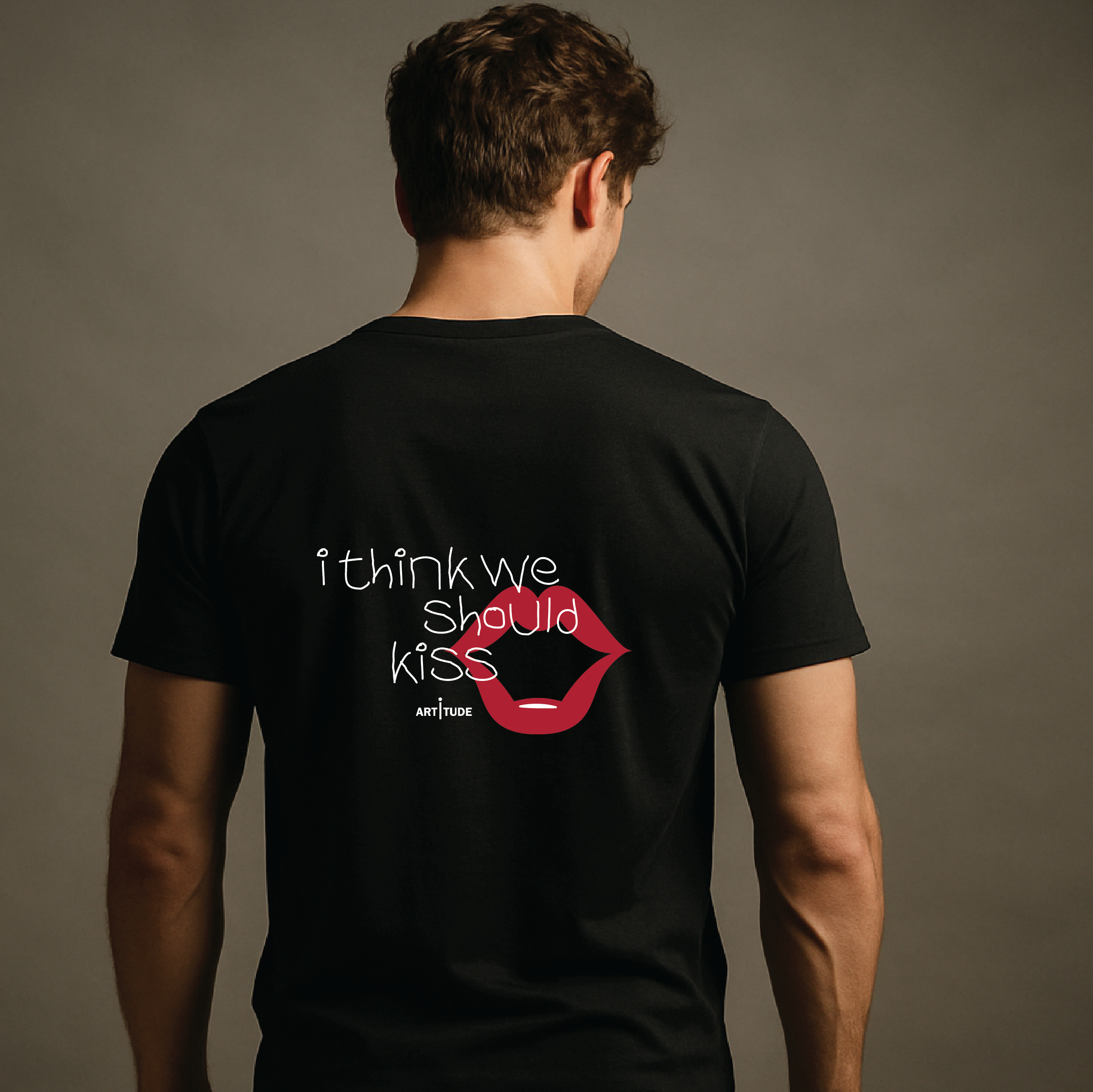 Person wearing a black t-shirt with a graphic and text on the back against a gray background